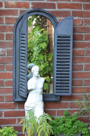 Socha Venuše před zahradním zrcadlem.